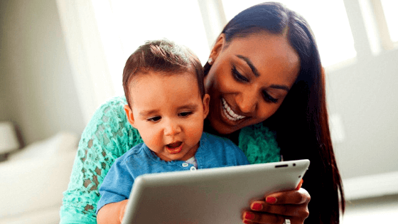 Imagem mostra mãe e filho brincando juntos em tablet. A imagem serve para questionar se o chamado vício digital é mesmo um risco para crianças pequenas.